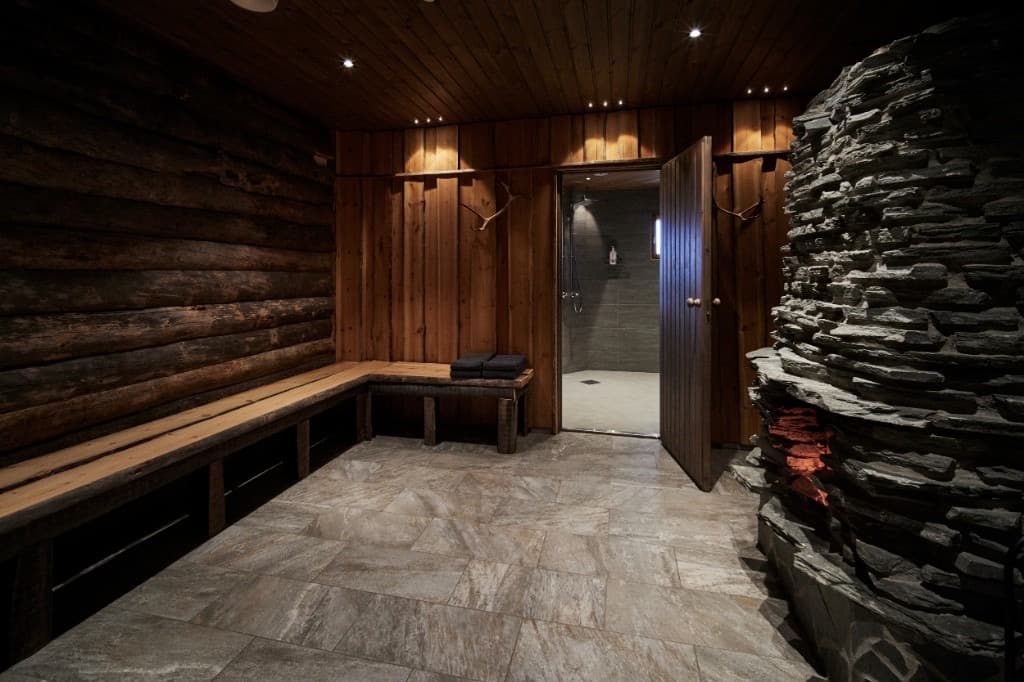 Log sauna with a stone shower room